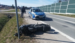 Kolizja motocykla z osobowym fordem. Na miejscu policja drogowa, oznakowany radiowóz z napisem Policja.