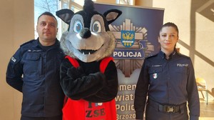 Dni otwarte w Zespole szkół Ekonomicznych w Brzozowie,. Policjanci zachęcali do pracy  w policji. Na zdjęciu umundurowany policjant i policjantka, maskotka szkoły wilk