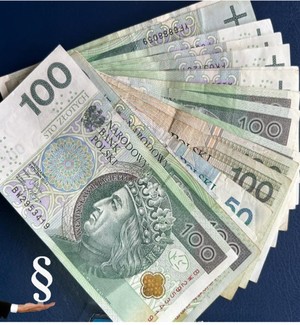 Zdjęcie przedstawia rozłożone banknoty polskiego złotego. Na pierwszym środku widoczny banknot o nominale stu złotych. Tło stanowi ciemno granatowy podkład. W lewym dolnym rogu zdjęcia widoczna wyciągnięta dłoń, która podtrzymuje symbol paragrafu.